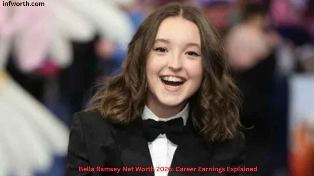 Bella Ramsey smiling at a red carpet event in a black tuxedo while attending a public appearance, featured in an article about Bella Ramsey Net Worth and career earnings.