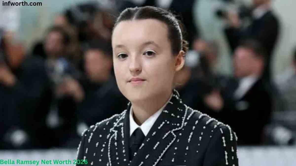 Bella Ramsey posing on the red carpet in a black patterned suit at a public event, featured in an article about Bella Ramsey Net Worth and career earnings.