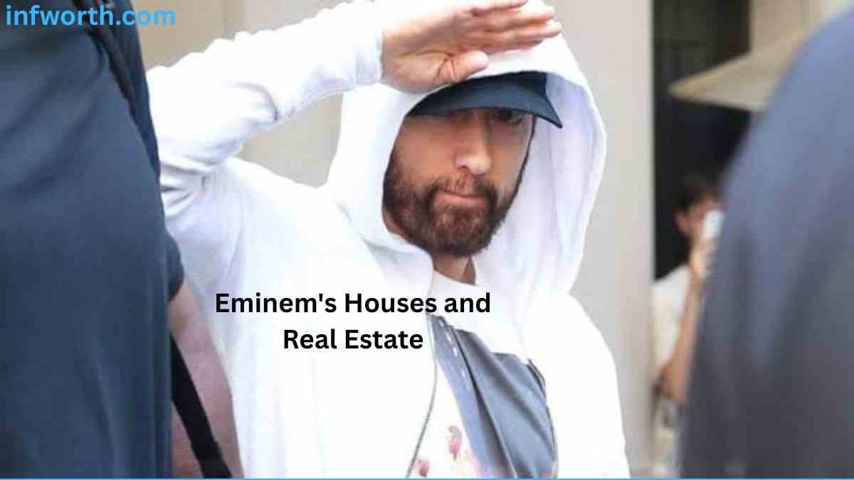 Eminem Net Worth – Eminem wearing a white hoodie and black cap in a public setting.