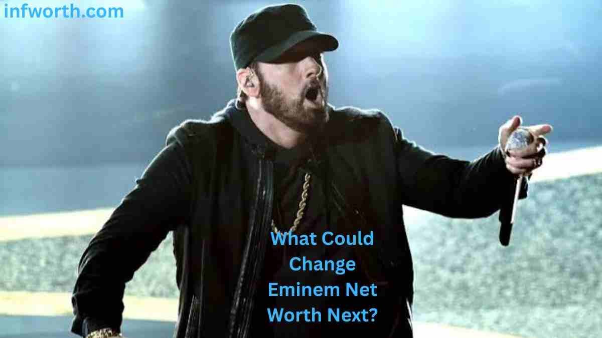 Eminem Net Worth – Eminem performing live on stage in a black cap and jacket while holding a microphone.